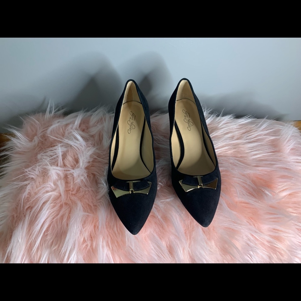 These black heels have a suede and light velvet texture. With gold accent peice.